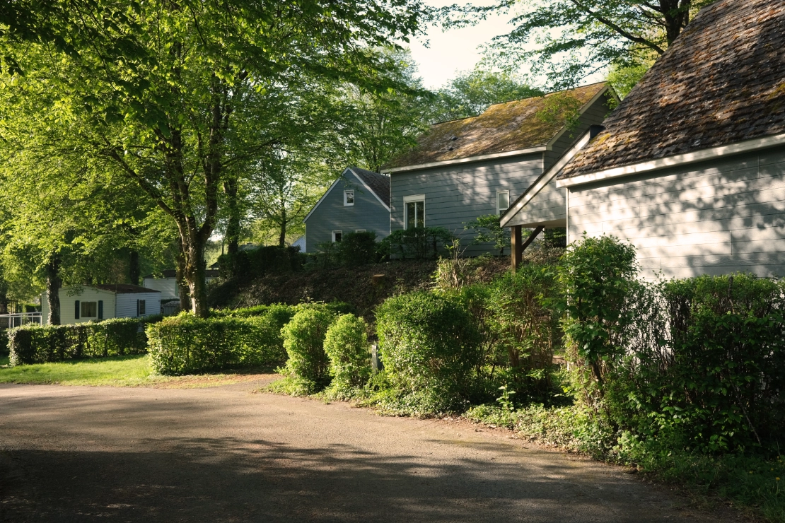 Allée arborée avec chalets au Camping Parc de Vaux en Mayenne